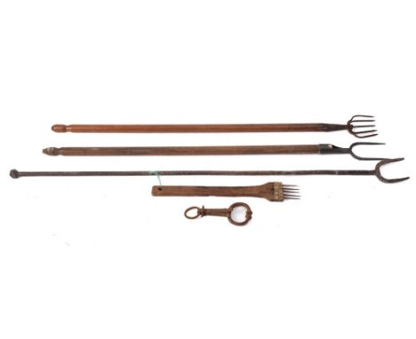 A wrought iron twin tine long handled toasting fork:, a twin tine fork with wood turned handle, an iron fish harpoon with tur