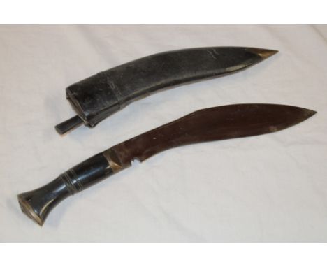 A Gurkha kukri with curved single edged blade, horn hilt and leather sheath 