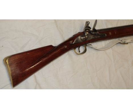 An old copy flintlock Brown Bess musket with 46" steel barrel, engraved lock with walnut stock, brass furniture and leather s