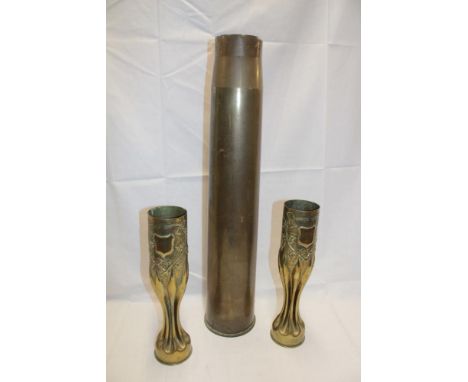 A large Second War brass shell case dated 1939, 26½" high and a pair of First War trench-art shell case vases with raised dec