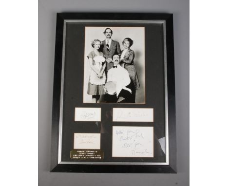 A framed set of Faulty Towers signatures mounted below monochrome photograph of cast. Includes John Cleese, Prunella Scales, 