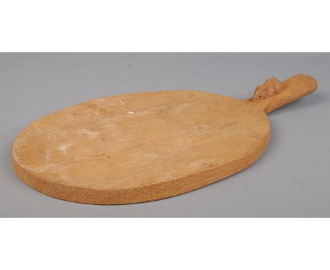 Robert 'Mouseman' Thompson, an oak cheese board with handle and signature mouse carving. Length 39.5cm.  