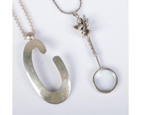 Two silver pendants on chains to include large letter C and small magnifying glass featuring harp playing cherub to handle. A