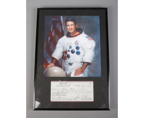 A framed James B. Irwin signed cheque paid to Radiant Church mounted below color photograph. Bears certificate of authenticit