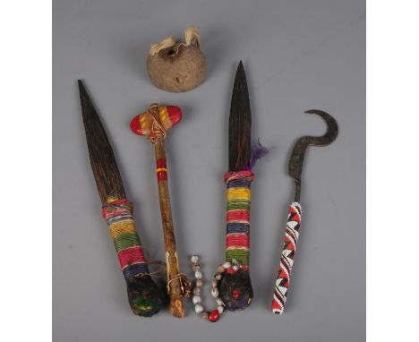 A good collection of mostly tribal carved weapons to include Cherokee axe, beaded sickle, etc.  
