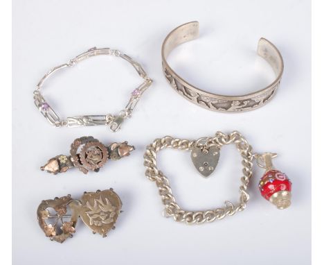 A collection of silver jewellery to include bangle engraved with village scene, charm bracelet, floral bracelet and  two broo