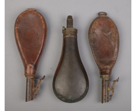 Two antique leather shot pouches along with a Cutts Patent powder flask.  Both leather examples splitting near nozzle, one so