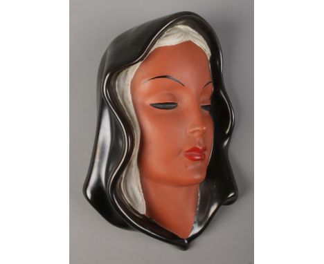 A Goldscheider wall mask portrait of a lady in head scarf. Impressed to back 7831. 22cm.  