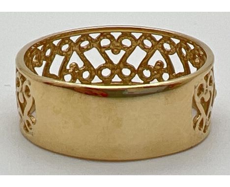 An 18ct gold pierced work band ring with scroll decoration &amp; empty cartouche. Full hallmarks to inside of band. Size T. W