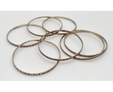 7 vintage silver bangles with matching diamond cut pattern. Marked Sterling silver to inside. Total weight approx. 44.5g. 