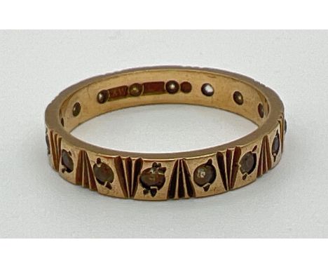 A vintage full eternity ring with engraved pattern and set with small round cut clear stones. Full hallmarks to inside of ban