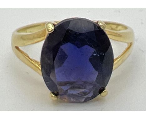 A 14K gold dress ring with a large oval cut claw set dark blue tanzanite stone. Gold marks to inside of band. Ring size P, to