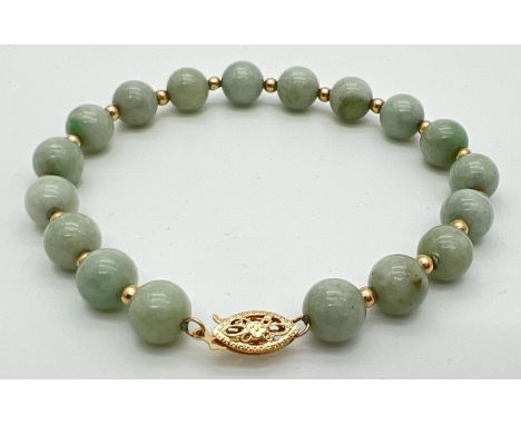 A green jade and 14ct gold bead bracelet with pierced work fishhook clasp. Alternating round green jade beads and small round