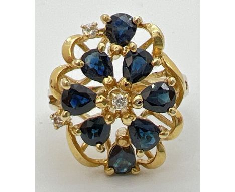 A 14k gold large open design mount dress ring set with sapphires and diamonds. 8 teardrop cut midnight blue sapphires and 3 s