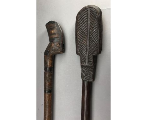 **A CARVED AUSTRALASIAN CLUB AND A CARVED AXE HAFT, LATE 19TH/20TH CENTURY the first with rectangular head carved with triang
