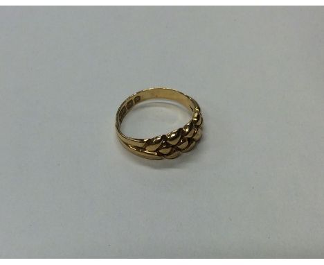 An 18 carat keeper ring of typical design. Approx. 3 grams. Est. £50 - £60.