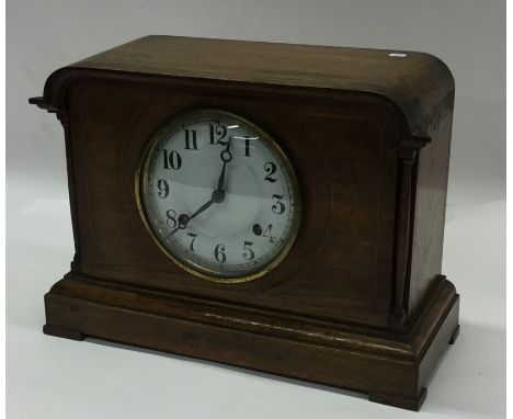 An oak cased mantle clock with white enamelled dial. Est. £20 - £30.