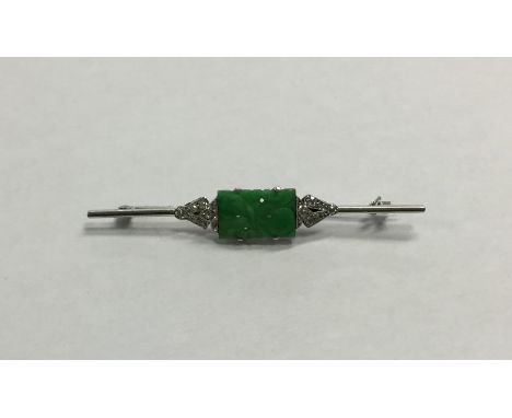 A stylish platinum, jade and diamond brooch of Oriental design in claw mount. Approx. 4.7 grams. Est. £250 - £300.