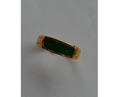 An 18 carat gold green stone ring with rubover mount. Approx. 2.3 grams. Est. £35 - £45.