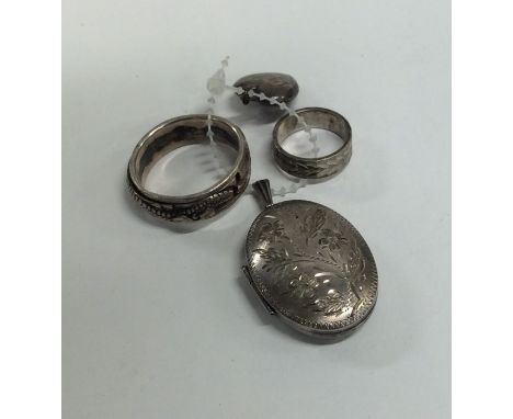 A small silver engine turned locket together with silver rings etc. Approx. 25 grams. Est. £15 - £20.