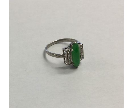 An Art Deco jade and diamond nine stone ring in platinum claw mount. Approx. 3.8 grams. Est. £700 - 3800.