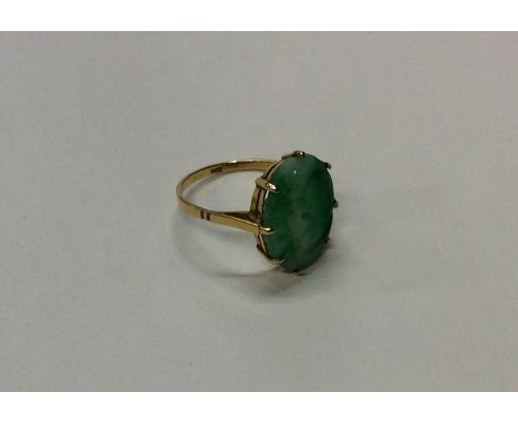 A gold and jade single stone ring in claw mount. Approx. 2.2 grams. Est. £30 - £50.