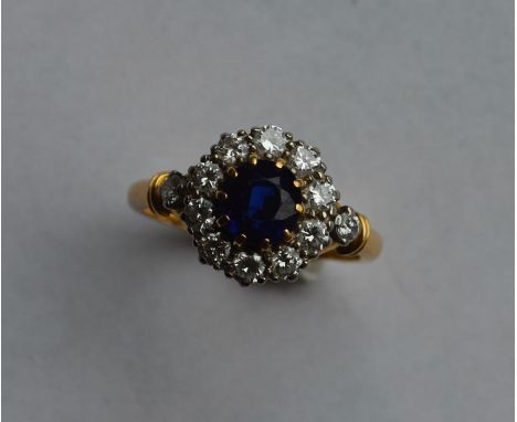 A sapphire and diamond circular cluster ring set in 18 carat and platinum claw mount. Approx. 4.8 grams. Est. £1200 - £1500.