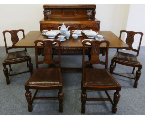 An oak dining suite comprising of an extending table and four chairs together with an oak carved sideboard.  The table being 