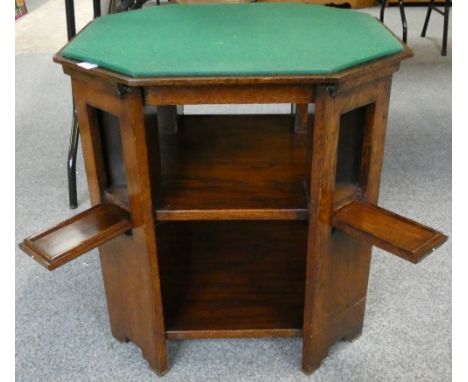 An oak octagonal table with reversible top to convert to games table each leg having a fold out shelf for glasses etc.