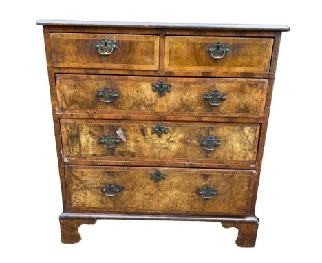 An early 18th century walnut chest of two short and three long drawers, the drawers having string inlaid and standing on shap