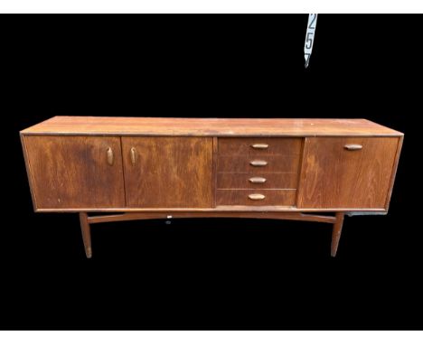 A 1960's Victor Wilkins for G-Plan 'Brasilia' teak sideboard, the four drawers flanked by a pair and single door, on tapering