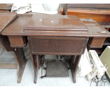 A vintage treadle sewing machine in oak case