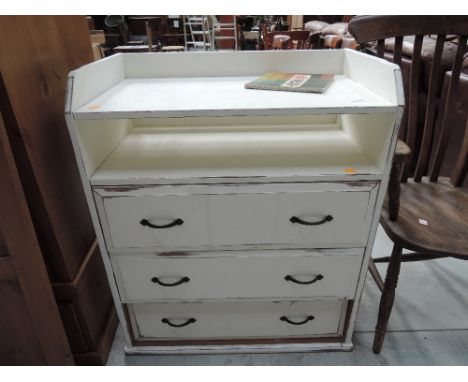 A shabby chic chest of three drawers with shelf