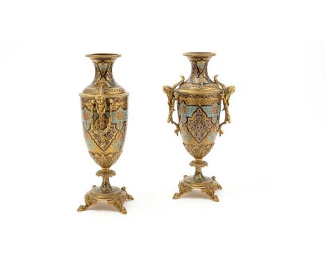 A pair of 19th Century French champleve enamel garniture vases, with figural and swag handles, raised of scrolling feet, 31cm