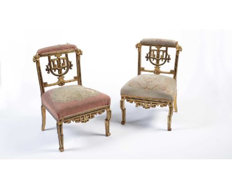 A pair of Napoleon III giltwood slipper chairs in the Chinese taste, the cushioned top rail over a decorative pierced geometr