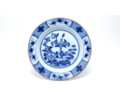 An English Delftware charger, circa 1760, probably Liverpool, decorated in the Chinese manner in blue with stylised vase, flo