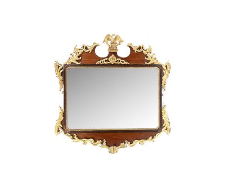 An ornate late 19th Century giltwood and mahogany wall mirror, in the mid 18th Century taste, the scrolled pediment with eagl