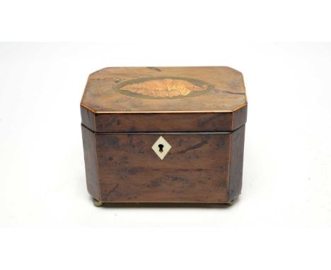 A George III yew wood tea caddy, of canted rectangular form, the cover with inlaid shell paterae and bone escutcheon, paper l