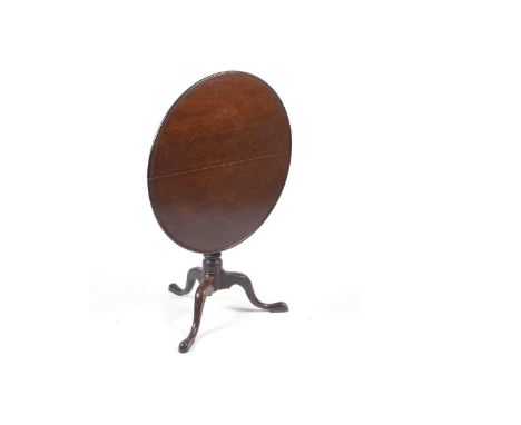 A George III mahogany tilt-action tripod table, the circular top over a single turned column, raised on downswept legs, 82 x 