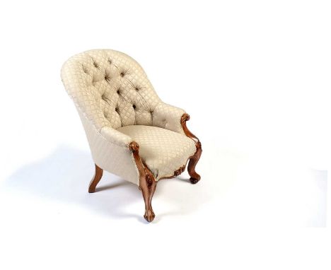 A Victorian carved walnut show frame and button-back easy chair, upholstered in cream fabric, with acanthus and floral detail