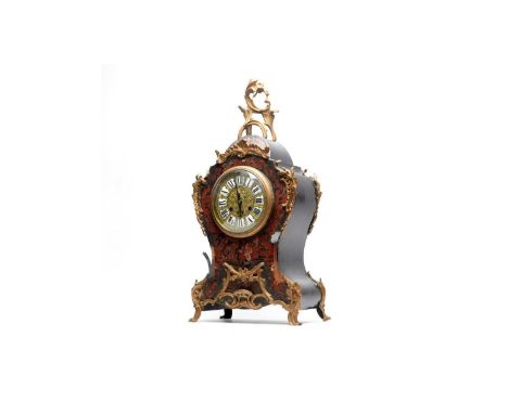 An ornate 19th Century French red Boulle bracket clock, the circular dial with raised Roman numeral enamel cartouches, eight-