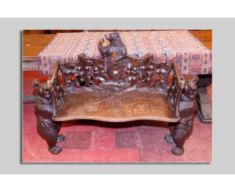 A German Black Forest carved bench with standing bear supports, leaf carved back and side supports with central carved standi