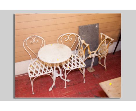 A painted cast iron tripod garden/pub table with circular white marble top and a pair of  metal garden chairs with latticed s