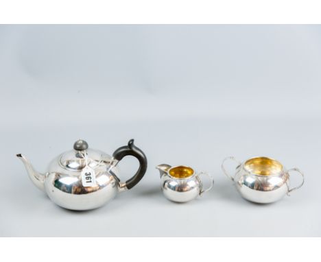 A three piece silver tea service, bullet shaped, the teapot with a composition handle, a twin handled sugar basin and cream j