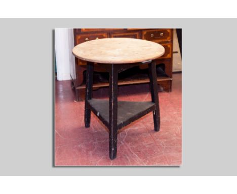 An antique pine cricket table with under tier shelf, 70 cms high, 65.5 cms diam