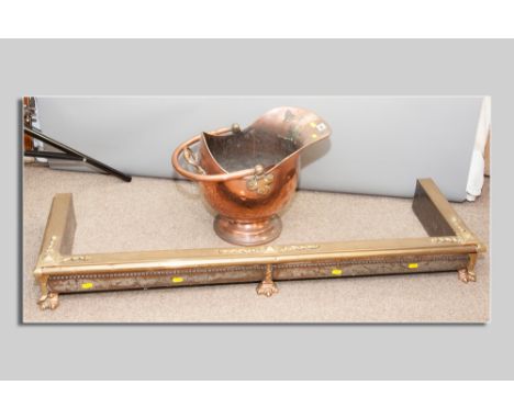 A copper helmet coal scuttle with swing handle, a brass and copper oblong fender on claw supports and a fireguard