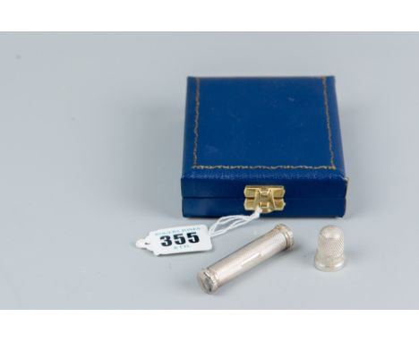 A cased silver cylindrical engine turned needle case, Birmingham 1968 and a silver thimble, Chester 1893