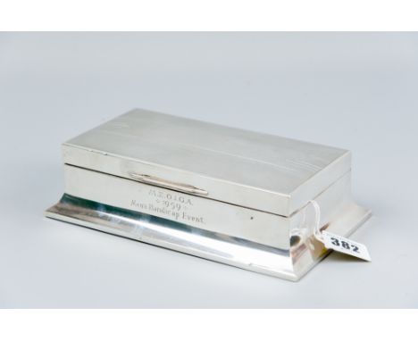 A large oblong engine turned silver cigarette box having a wider concave base and with golf presentation inscription to the f