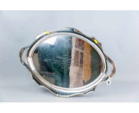 A large oval silver twin handled tray having a wavy border and the 'handles' of pierced form as part of the border, inscribed