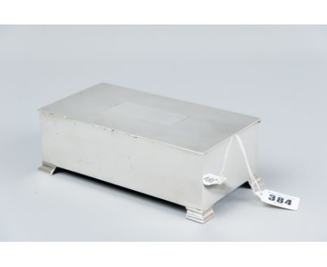 An oblong plain silver cigarette box with engine turned lid and corner bracket feet, London 1947